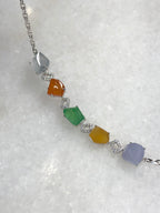 Multi-coloured natural Type A faceted jadeite bracelet featuring green, orange-red, yellow, lavender and icy white jade with diamond-set geometric links in 18K white gold.