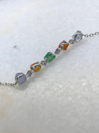 Multi-coloured natural Type A faceted jadeite bracelet featuring green, orange-red, yellow, lavender and icy white jade with diamond-set geometric links in 18K white gold.
