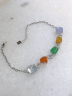 Multi-coloured natural Type A faceted jadeite bracelet featuring green, orange-red, yellow, lavender and icy white jade with diamond-set geometric links in 18K white gold.